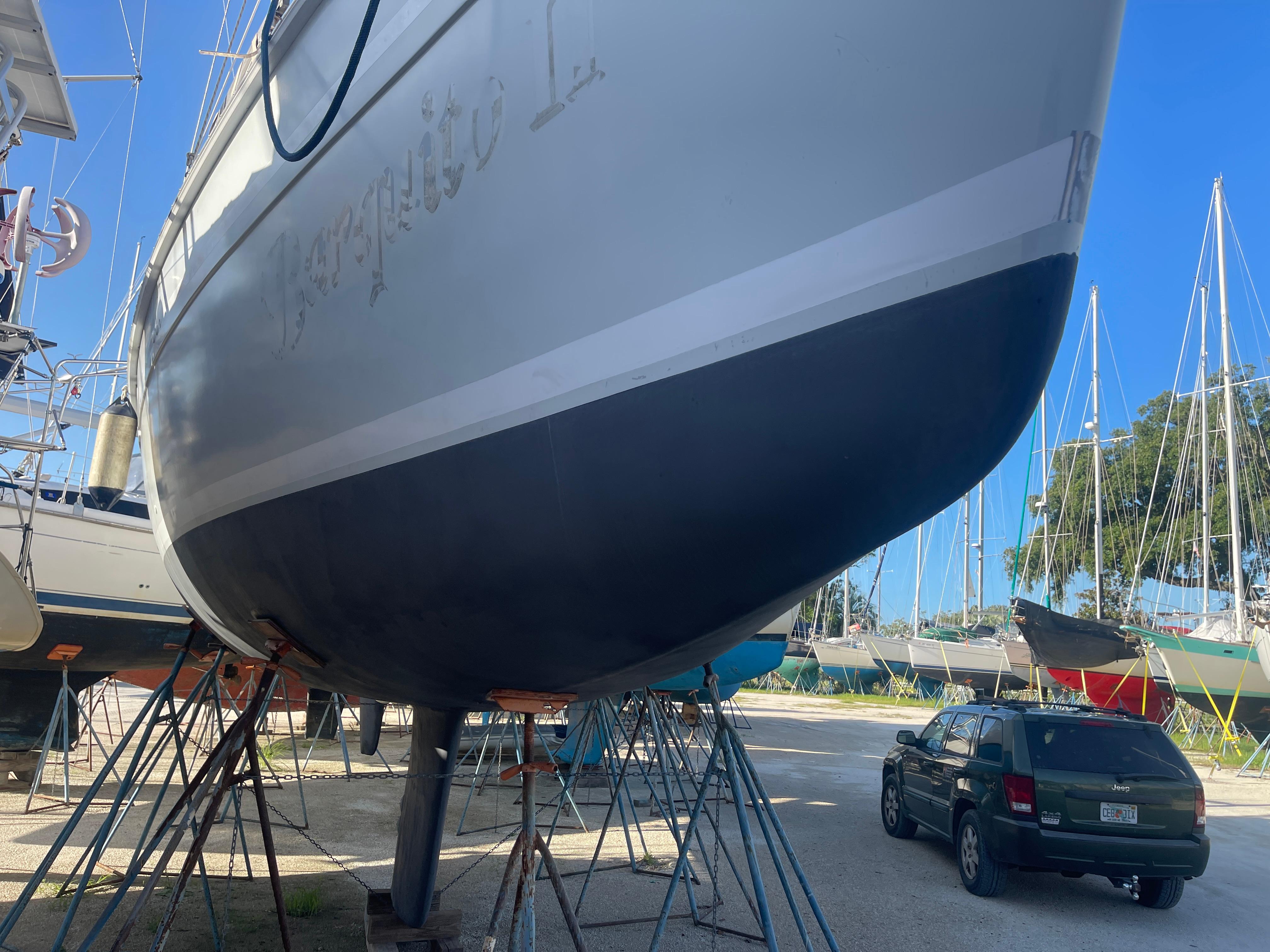 Hunter 44 DS Deck Salon 2004 Hunter 44 DS Deck Salon sailboat on stands in a boatyard, with a car nearby.