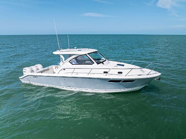 Pursuit OS 355 Offshore 2025 Pursuit OS 355 Offshore boat cruising on open sea under clear blue sky.