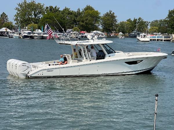 Pursuit S 428 Sport 2022 Pursuit S 428 Sport boat cruising on a calm lake with trees in the background.