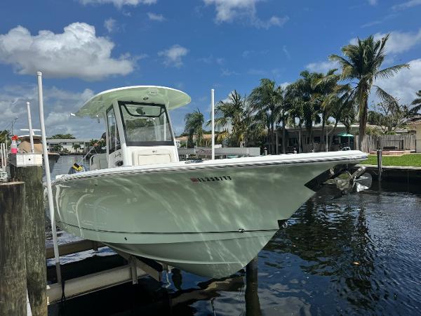 Sea Hunt Gamefish 27 2022 Sea Hunt 27 Gamefish boat docked near palm trees and waterfront homes.