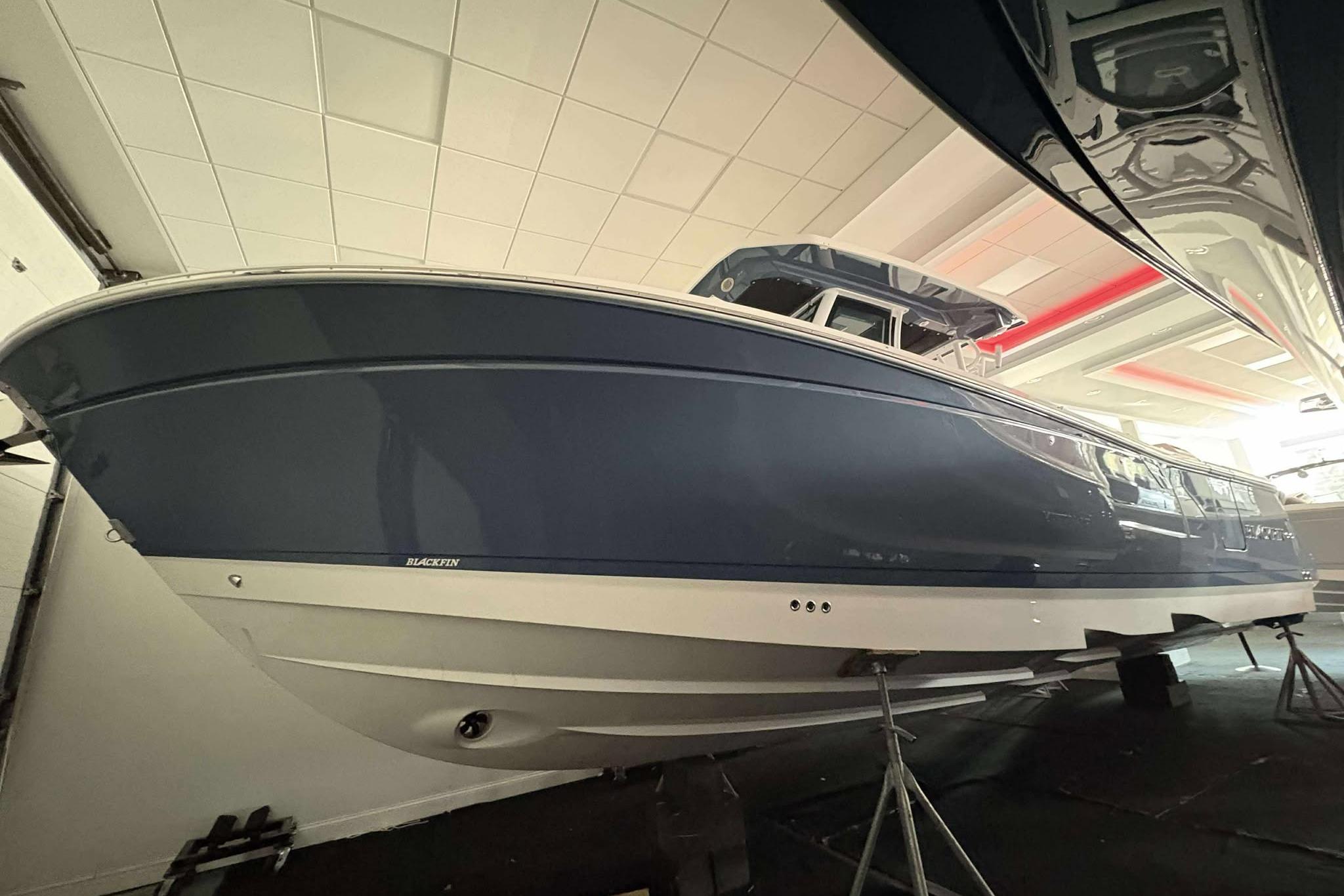 Blackfin 302 CC 2025 Blackfin 302 CC boat in showroom, blue hull, sleek design.