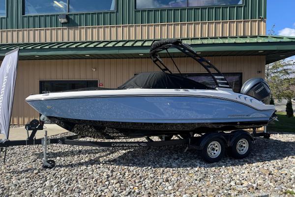 Chaparral 21 SSi OB 2025 Chaparral 21 SSi OB boat on trailer, parked outside a building.