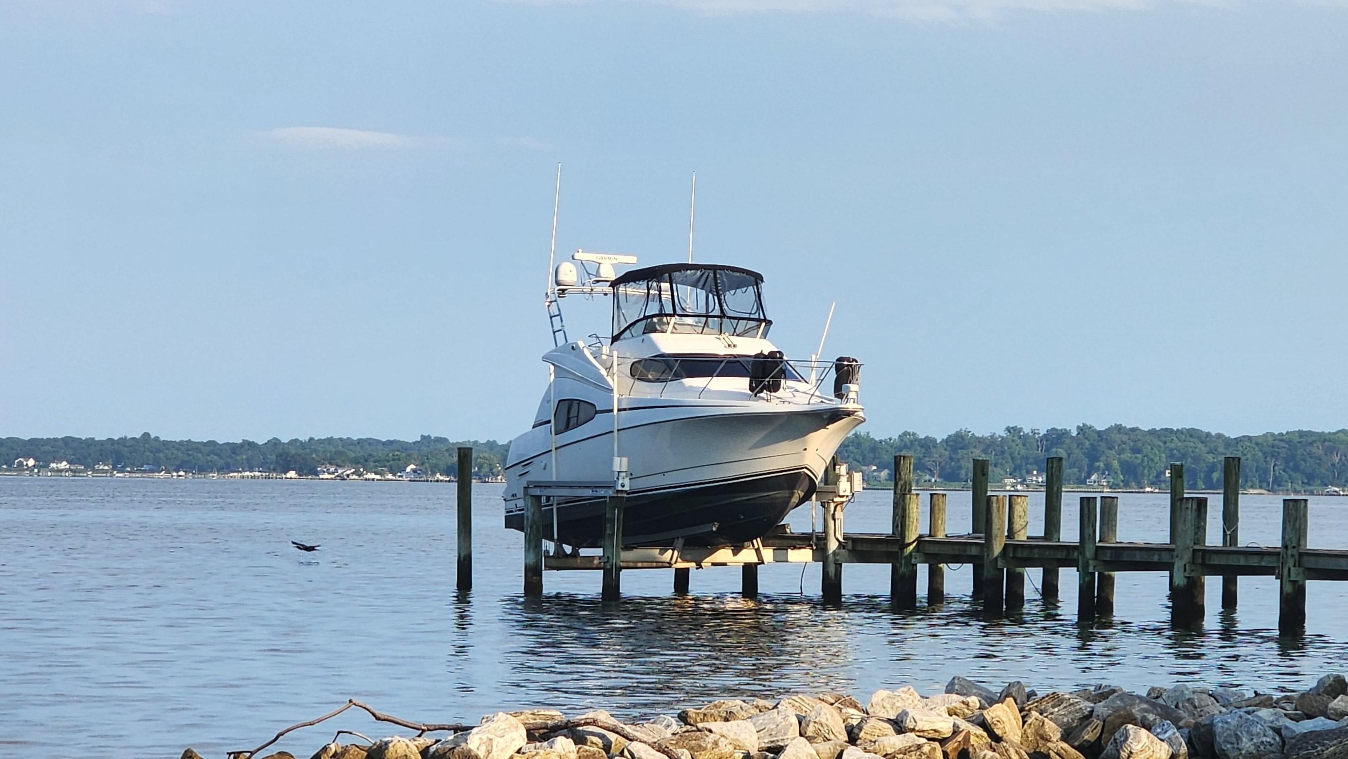 Silverton 330 Sport Bridge 2002 Silverton 330 Sport Bridge yacht docked on a serene lake.