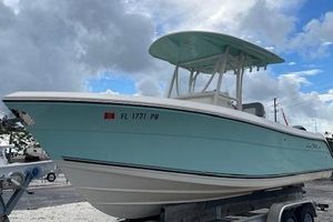 Cobia 237 Center Console 2014 Cobia 237 Center Console boat on trailer, light blue hull, cloudy sky background.