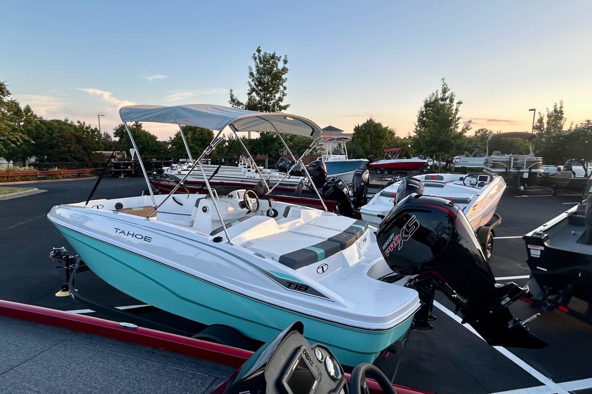 Tahoe T18 2025 Tahoe T18 boat with canopy, parked outdoors at sunset.