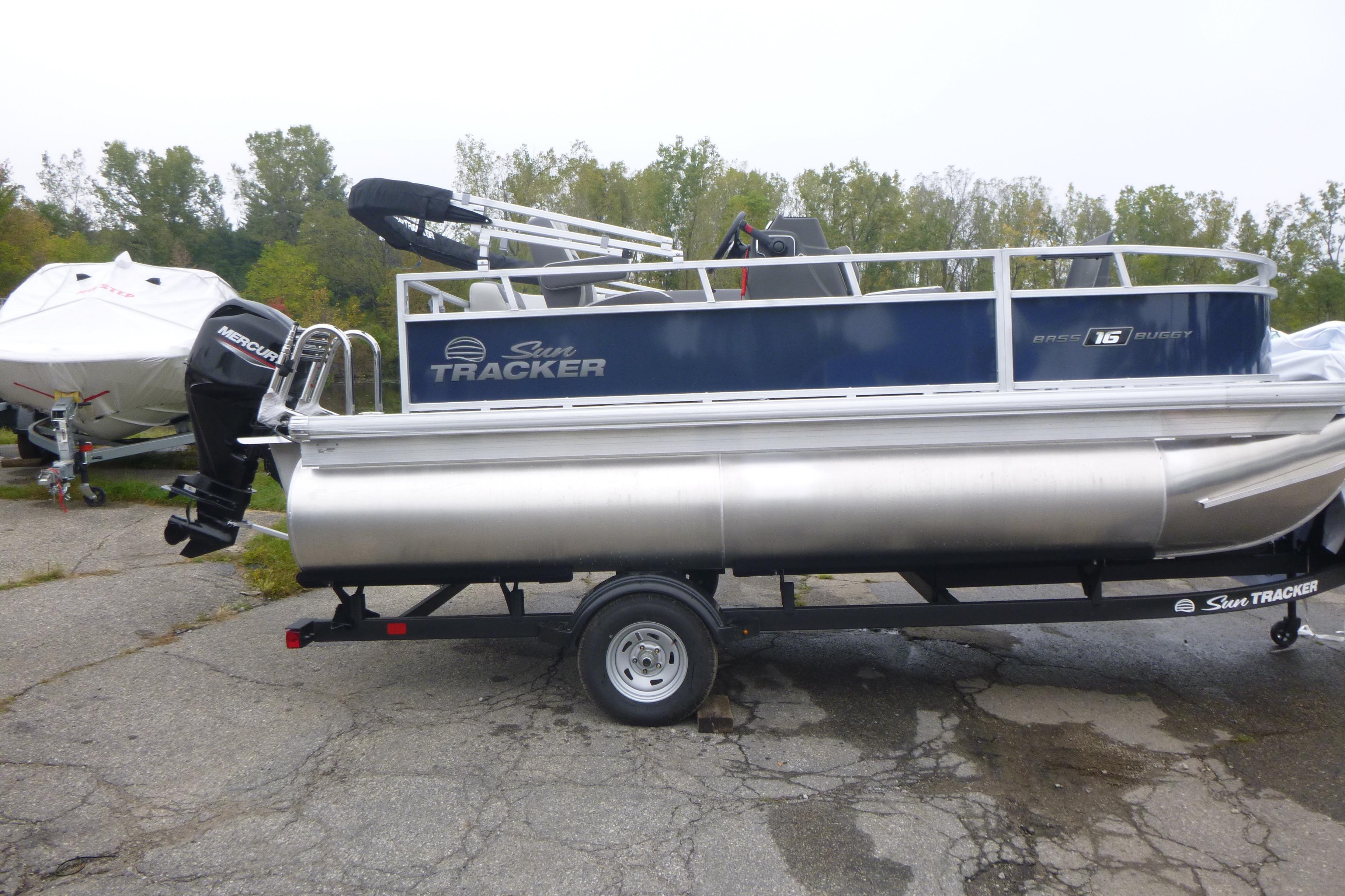 Sun Tracker Bass Buggy 16 XL Select 2026 Sun Tracker Bass Buggy 16 XL Select pontoon boat on trailer, parked outdoors.