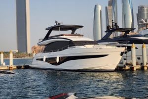 Princess Y72 2025 Princess Y72 Motor Yacht docked in a marina with modern skyscrapers in the background.