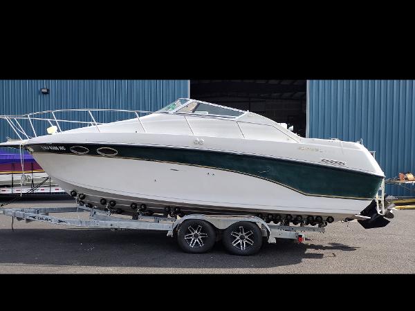Crownline 250 CR 1997 Crownline 250 CR boat on a trailer in front of a blue building.