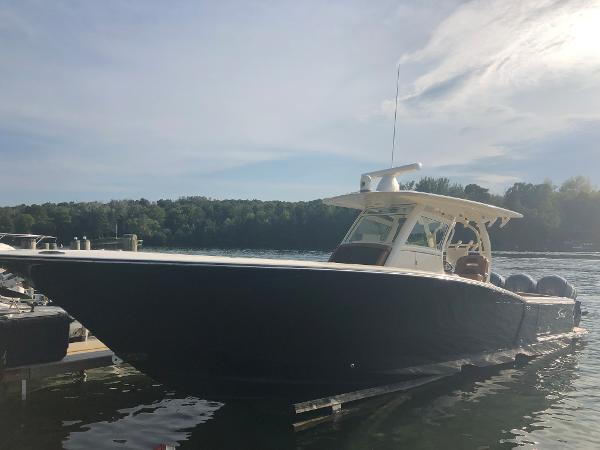 Scout 350 LXF 2016 Scout 350 LXF boat docked on a sunny day with trees in the background.