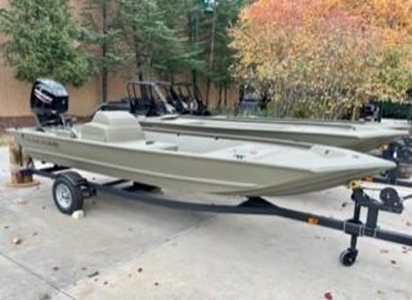 Tracker Grizzly 1648 SC 2025 Tracker Grizzly 1648 SC boat on trailer, parked outdoors near trees.