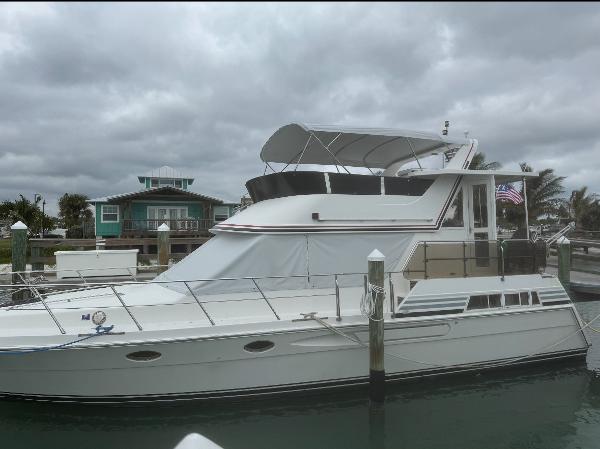 President 445 SUNDECK 1994 President 445 Sundeck yacht docked at marina under cloudy skies.