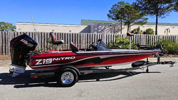 Nitro Z19 2025 Nitro Z19 boat, red and black design, parked outdoors.