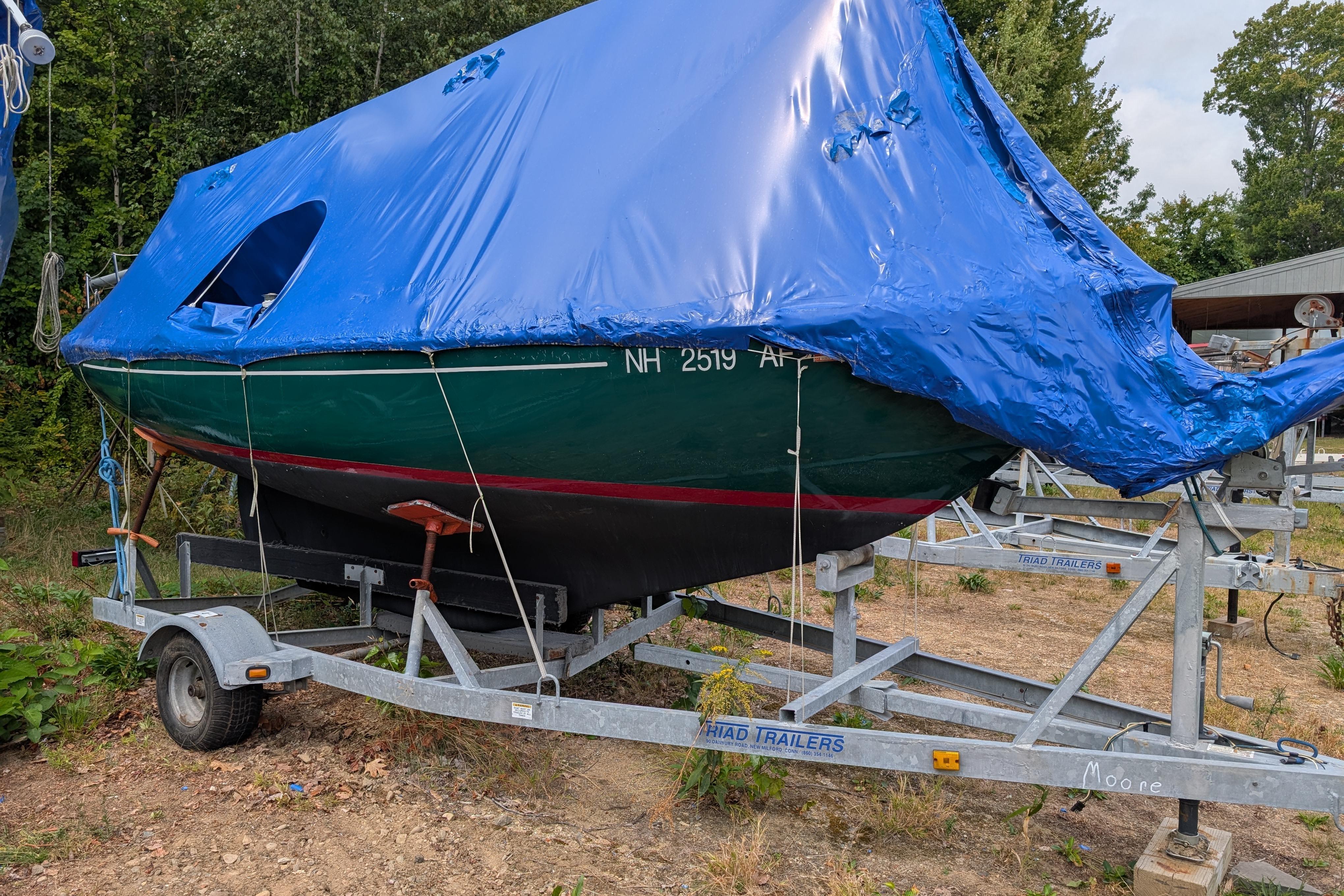 Cape Dory Typhoon 1981 Cape Dory Typhoon sailboat on trailer, covered with blue tarp, parked outdoors.