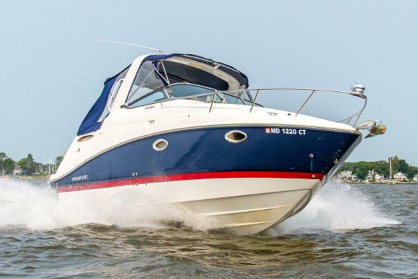 Rinker EX 270 2018 Rinker EX 270 boat cruising on water, blue and white design, side view.