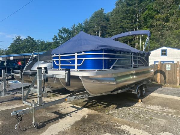 Bennington 20SVSR 2024 Bennington 20SVSR pontoon boat on trailer, covered, parked outdoors.