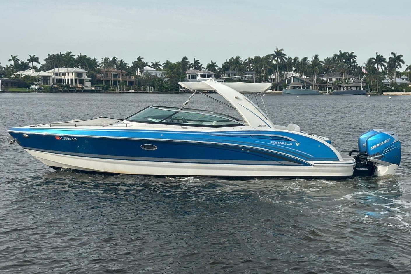 Formula 310 Bowrider 2020 Formula 310 Bowrider boat with blue exterior on a calm lake.