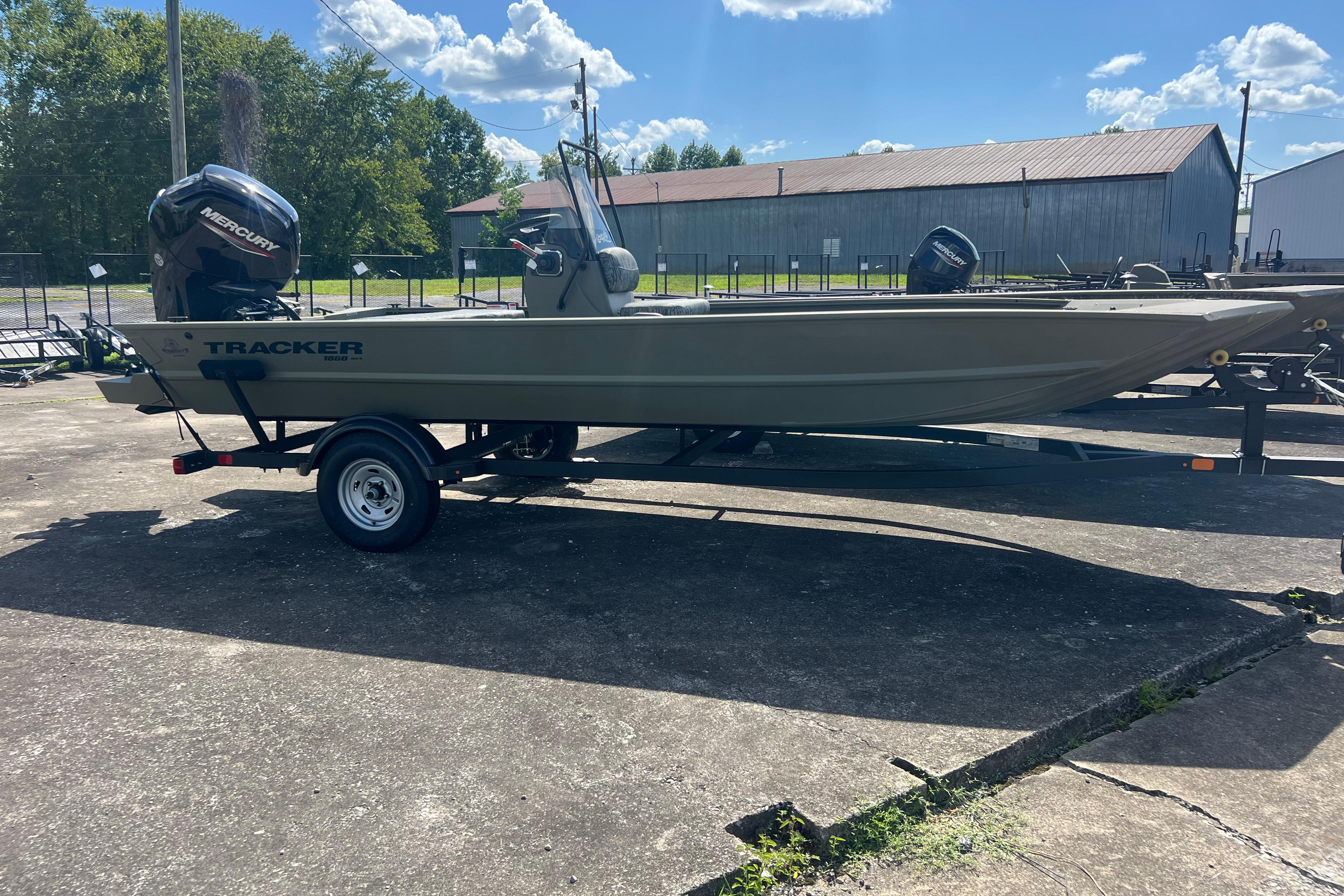 Tracker Grizzly 1860 CC 2026 Tracker Grizzly 1860 CC boat on trailer, outdoors under blue sky.