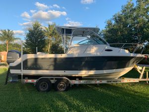 Robalo R245 Walkaround 2015 Robalo R245 Walkaround boat on trailer, parked on grass under a clear sky.