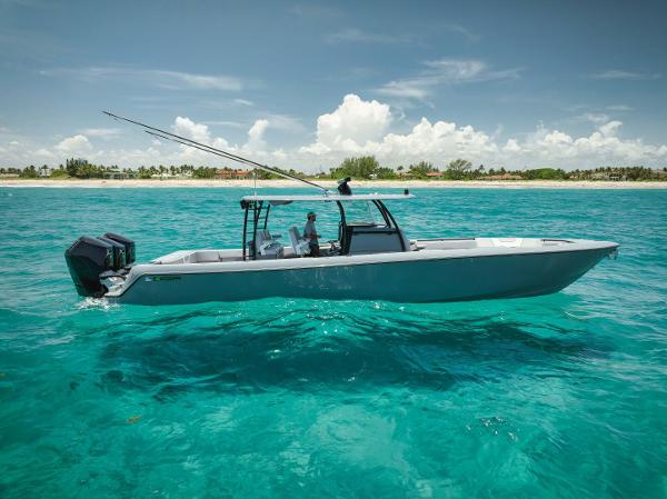 Contender 44 ST 2024 Contender 44ST boat cruising in clear turquoise waters near a tropical shoreline.