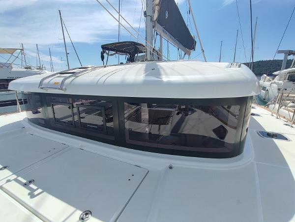 Lagoon 40 2024 Lagoon 40 catamaran with sleek design and spacious windows in a marina setting.