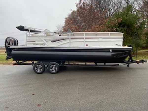 Ranger Reata 223C 2023 Ranger Reata 223C pontoon boat on trailer, parked on a road.