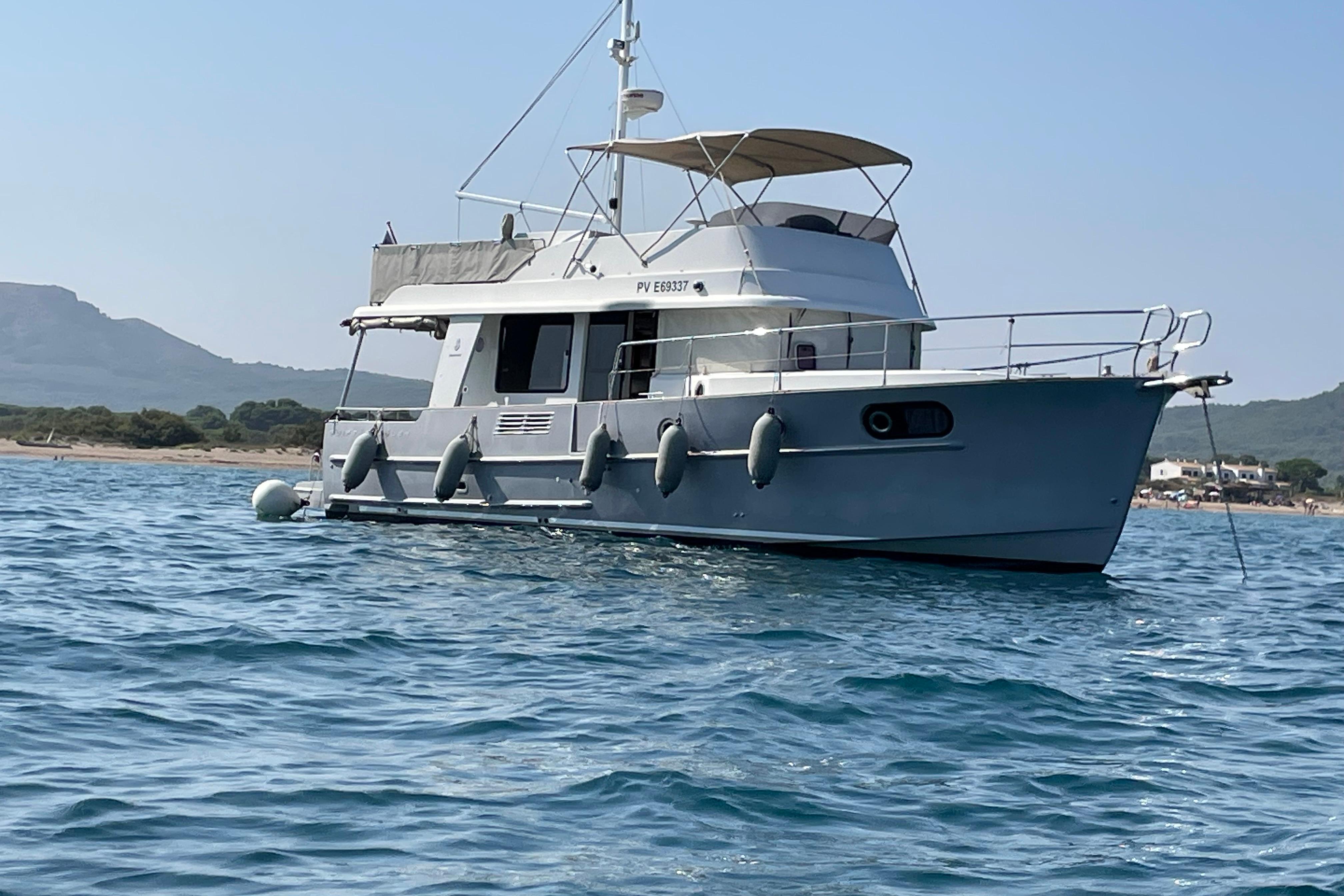 Beneteau Swift Trawler 44 2012 Beneteau Swift Trawler 44 anchored in calm waters near a scenic coastline.