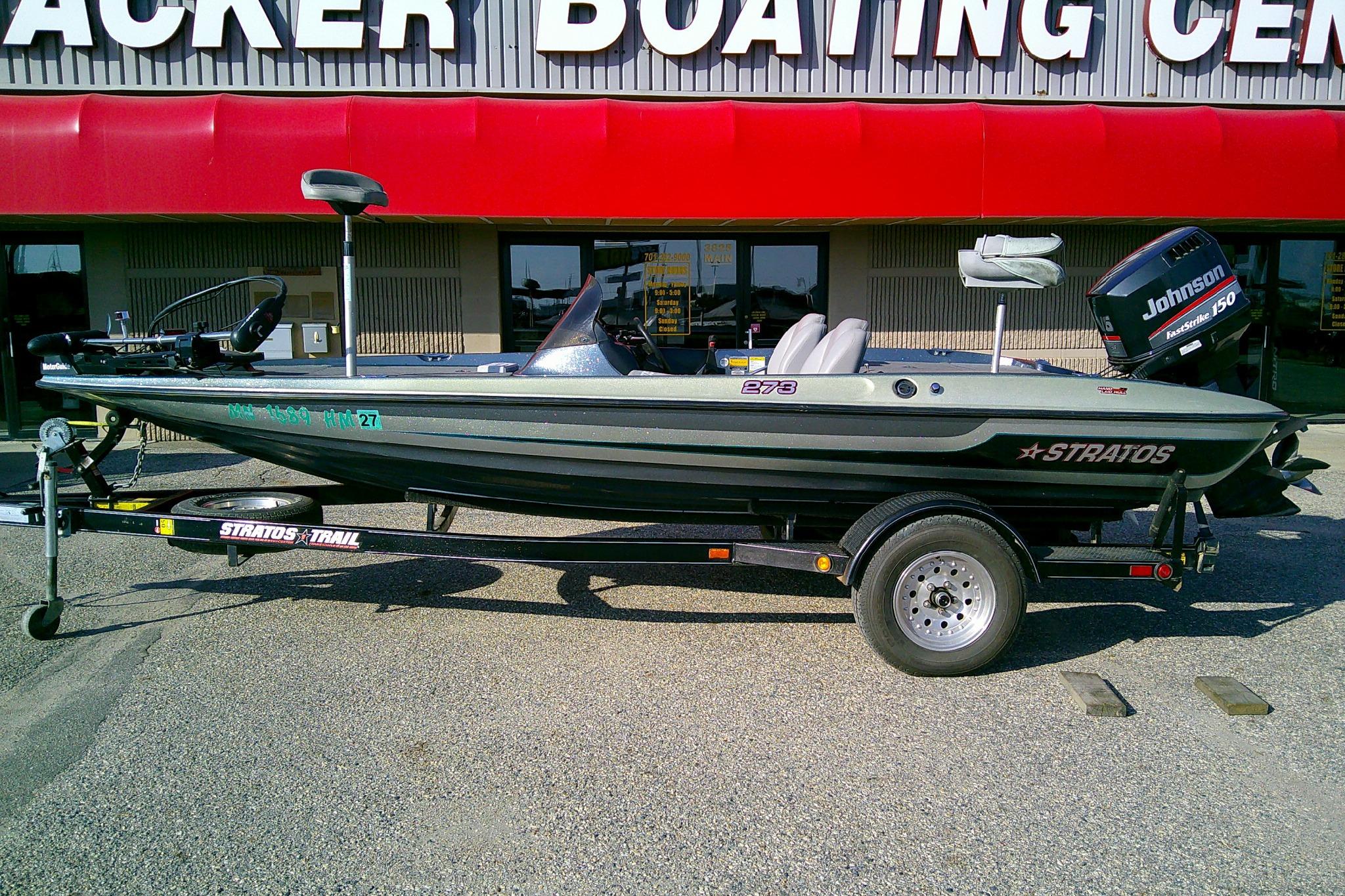 Stratos 273 V 1998 Stratos 273 V fishing boat with Johnson 150 motor on trailer, outside boating center.