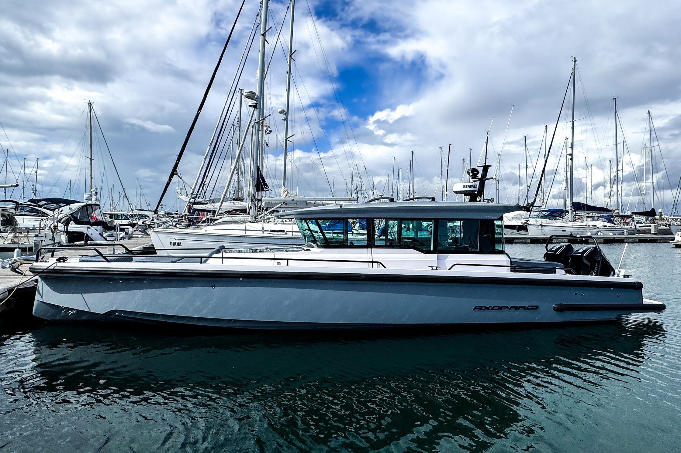 Axopar 37 XC CROSS CABIN 2023 Axopar 37 XC CROSS CABIN boat docked in a marina under cloudy skies.