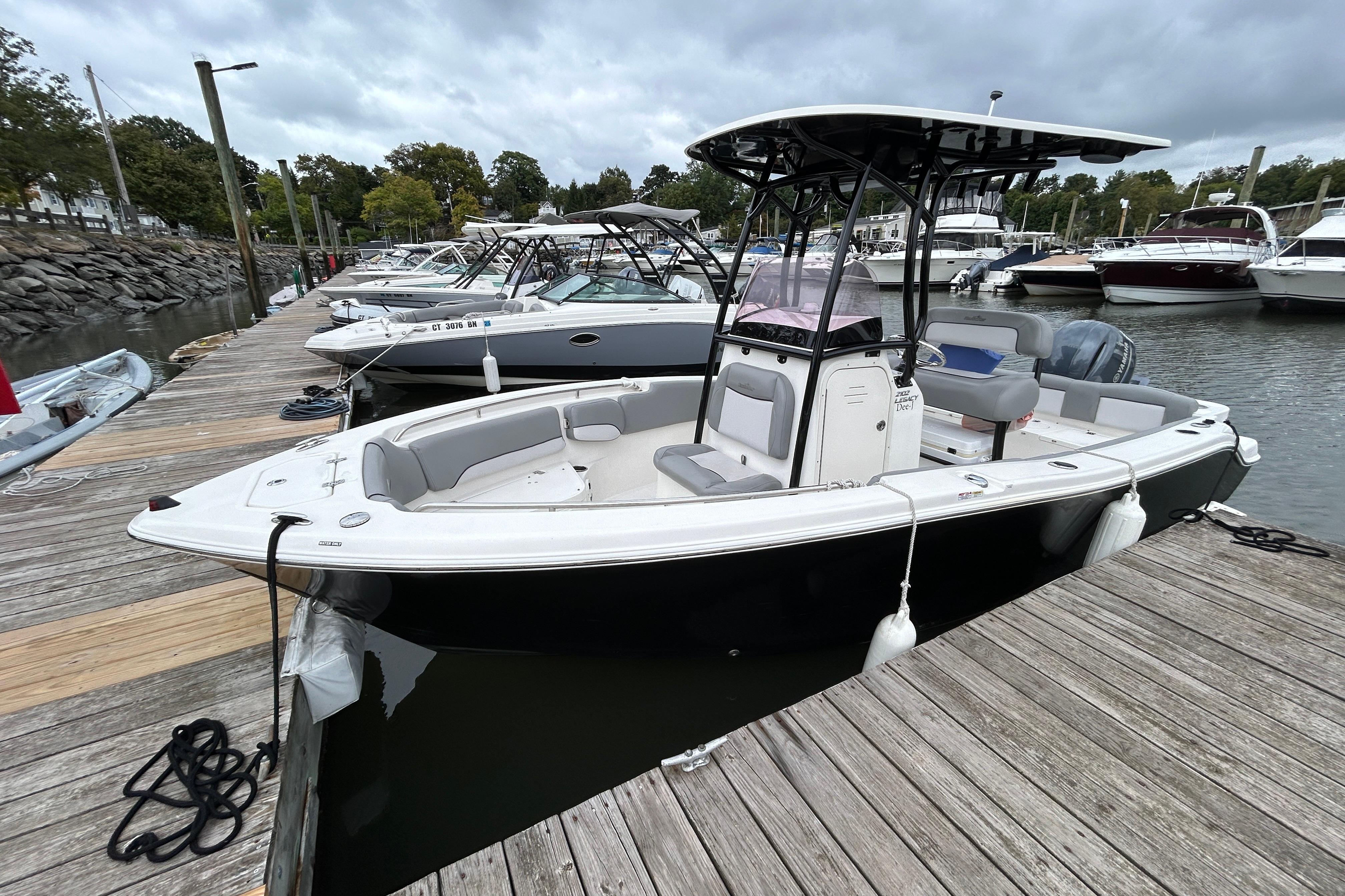 NauticStar 2102 Legacy 2021 NauticStar 2102 Legacy boat docked at a marina, surrounded by other vessels.