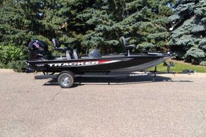 Tracker Pro Team 190 2026 Tracker Pro Team 190 boat on trailer, parked outdoors with trees in background.