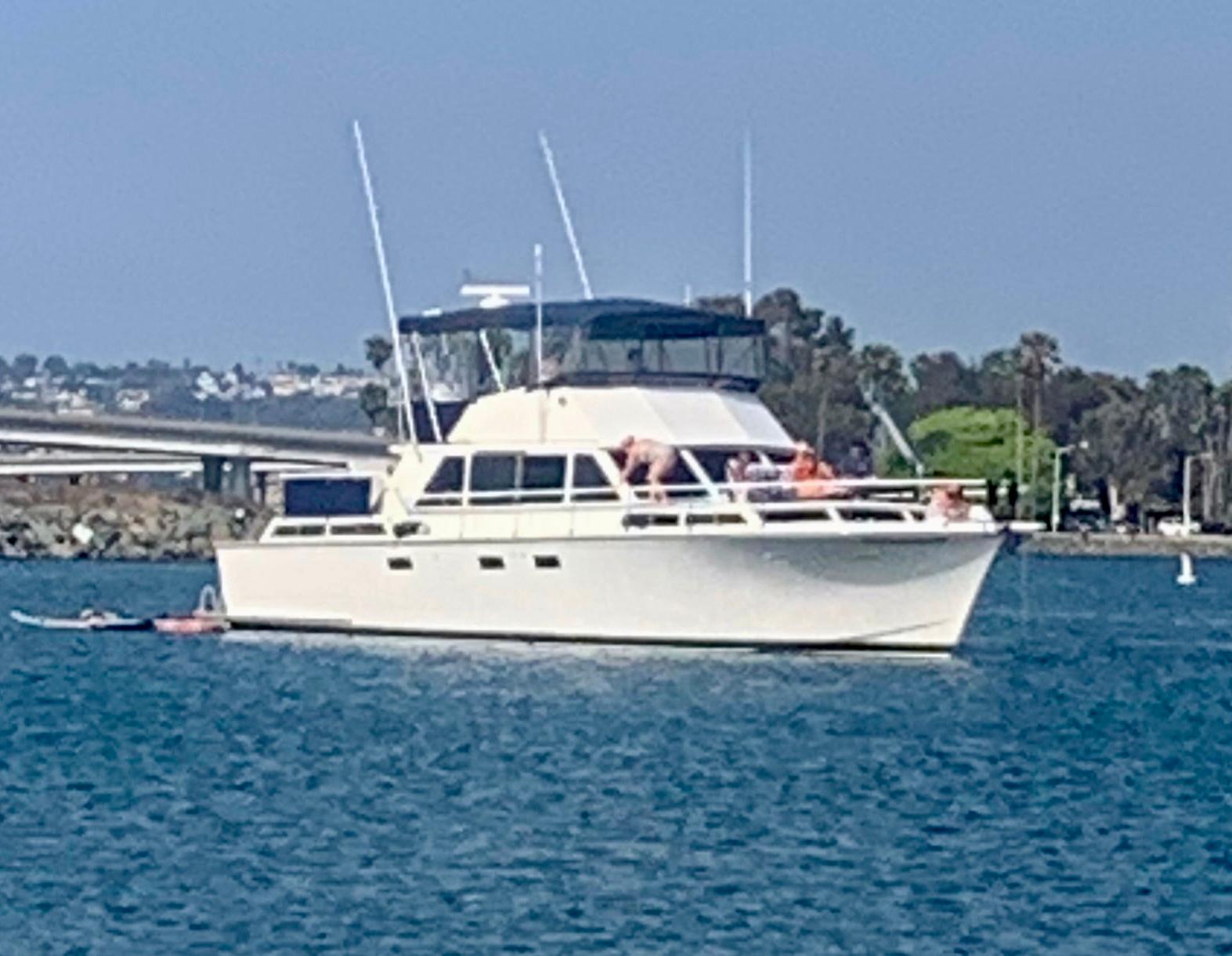 Custom Cockpit Motor Yacht 1979 Custom Cockpit Motor Yacht cruising on a sunny day, with people relaxing on deck.