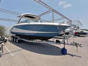 Sea Ray SLX 310 Outboard 2023 Sea Ray SLX310 boat on trailer under metal canopy, sunny day.