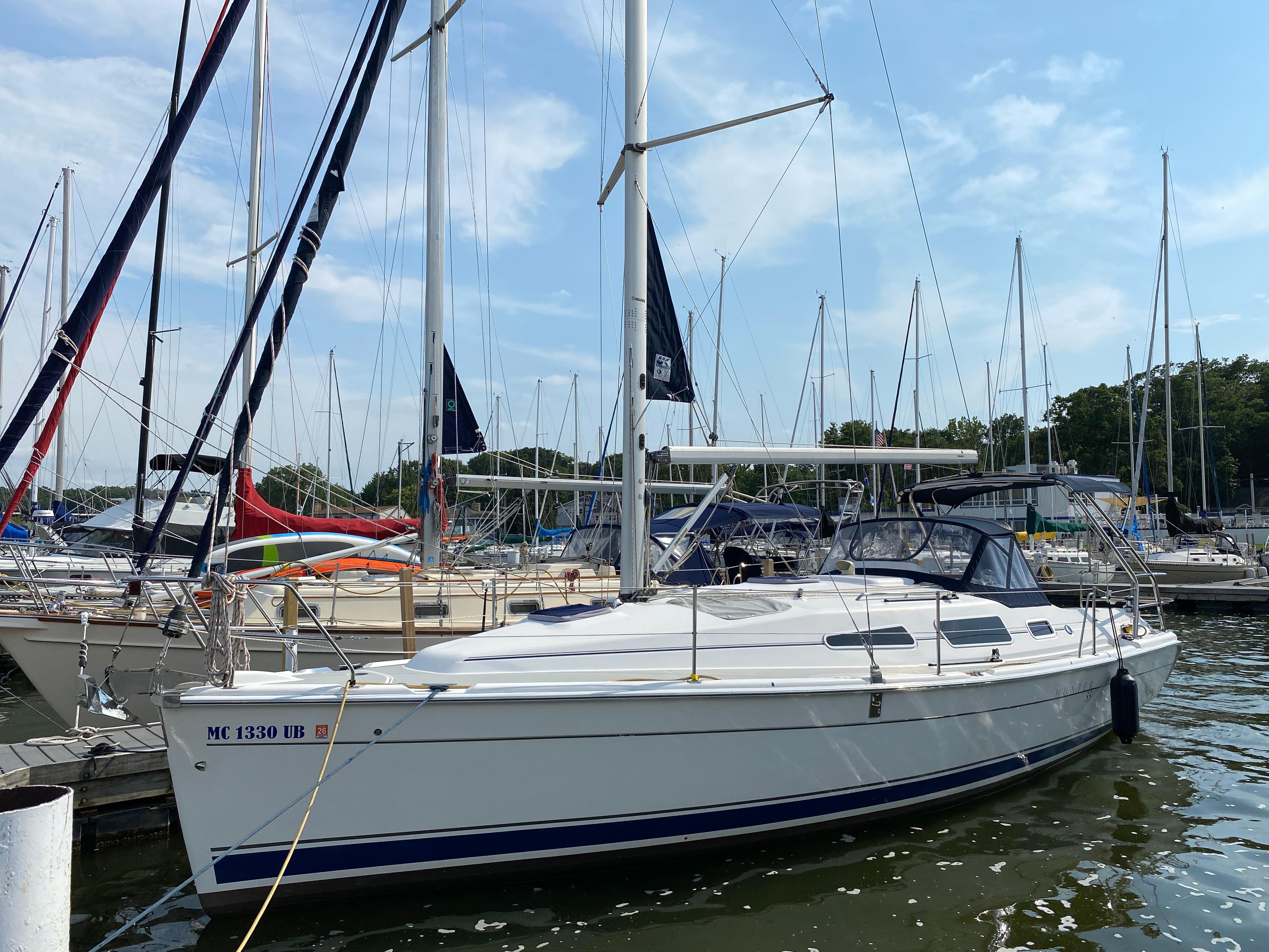 Hunter 33 2008 Hunter 33 sailboat docked in a marina, surrounded by other sailboats.