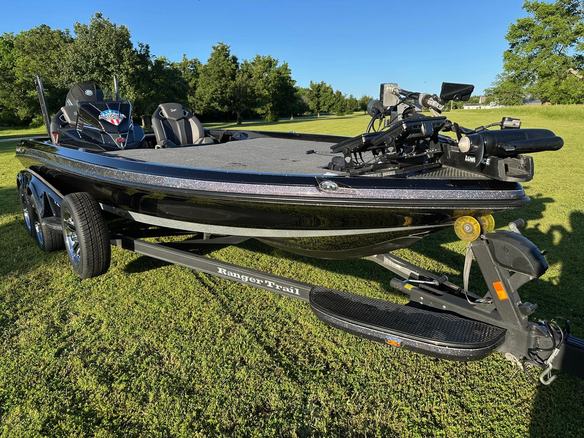 Ranger Z521R 2023 Ranger Z521R bass boat on trailer, parked on grass with trees in background.