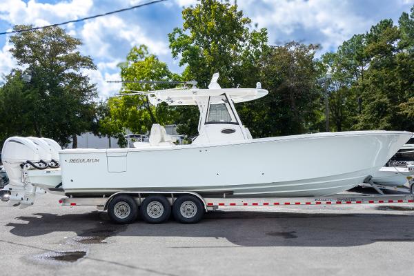 Regulator 34 2023 Regulator 34 boat on trailer, parked outdoors with trees in background.
