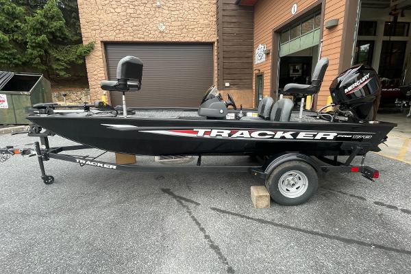 Tracker Pro 170 2025 Tracker Pro 170 boat on trailer, parked outside a garage.