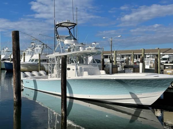 Regulator 41 2016 Regulator 41 boat docked in marina, clear sky, calm water reflection.
