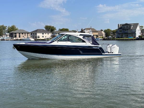 Formula 380 Super Sport Crossover OB 2025 Formula 380 Super Sport Crossover OB on calm water near waterfront homes.