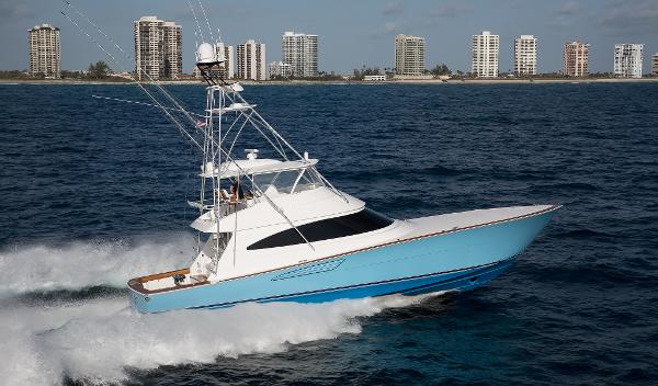 Viking 68 Convertible 2025 Viking 68 Convertible yacht cruising on the ocean near a city skyline.