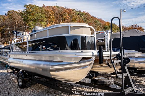 Sun Tracker Party Barge 16 2025 Sun Tracker Party Barge 16 pontoon boat on trailer, parked outdoors.