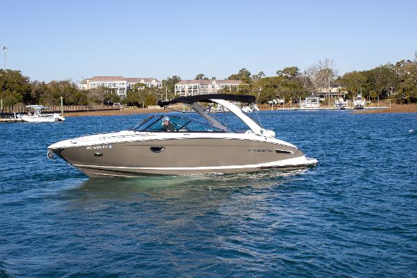 Regal 2800 2015 Regal 2800 boat cruising on a sunny day in a scenic waterway.