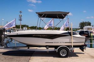 Starcraft SVX 171 OB 2023 Starcraft SVX 171 OB boat on trailer, dockside with flags and clear sky.