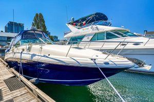 Sea Ray 320 Sundancer 2004 Sea Ray 320 Sundancer docked at marina under clear blue sky.