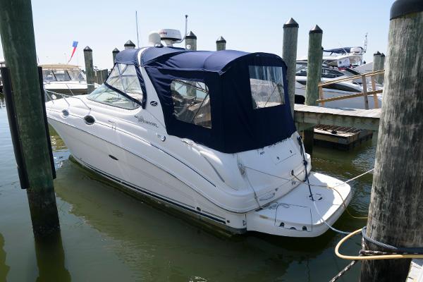 Sea Ray 280 Sundancer 2005 Sea Ray 280 Sundancer docked with blue canopy in marina.