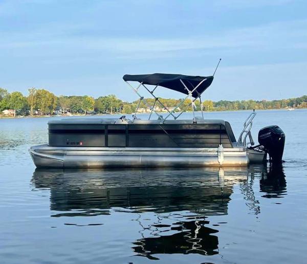 Crest Classic LX 220 2021 Crest Classic LX 220 pontoon boat on a calm lake.