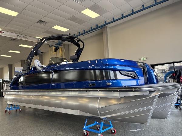Manitou 25 XT SRS SHP 2024 Manitou 25 XT SRS SHP pontoon boat in showroom, featuring sleek blue design.
