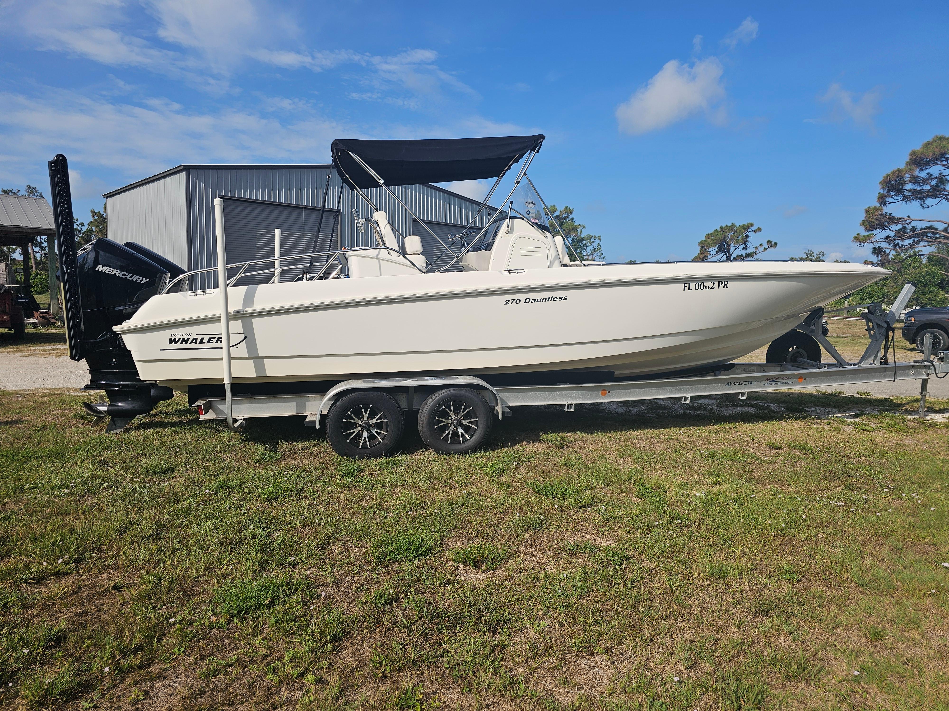 Boston Whaler 270 Dauntless 2014 Boston Whaler 270 Dauntless boat on trailer, parked outdoors under blue sky.