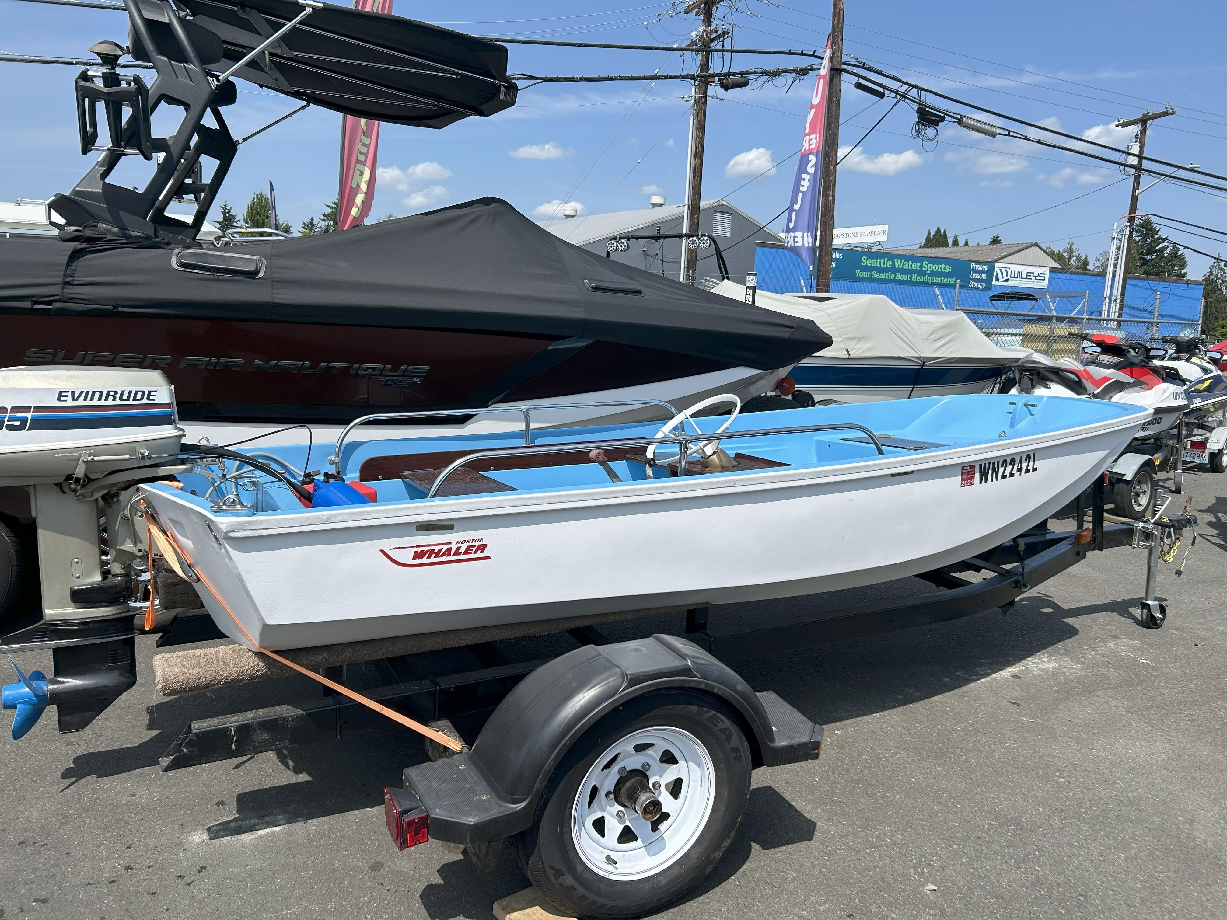 Boston Whaler 13 Sport 1966 Boston Whaler 13 Sport boat on trailer, parked outdoors, with Evinrude motor.