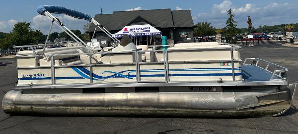 Crest II 1998 Crest II pontoon boat with blue accents, parked outdoors.