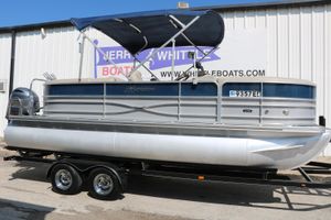 Berkshire 22 RFX Cts Tri-toon 2017 Berkshire 22 RFX Cts Tri-toon boat on trailer, with canopy, parked outside.
